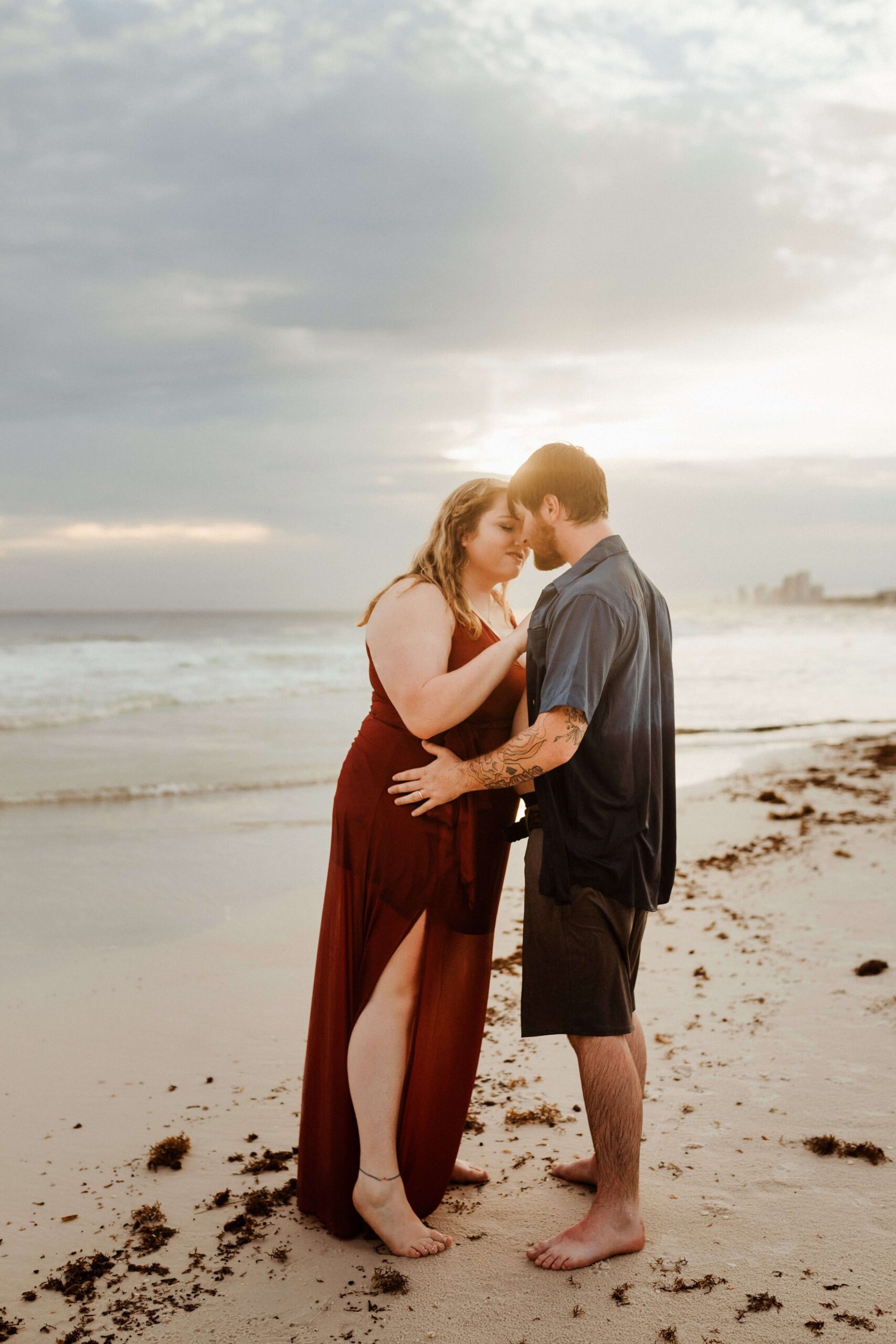 young couple on honeymoon kissing on panama city beach.  Photo taken by Brittney Stanley of Be Seen Photos