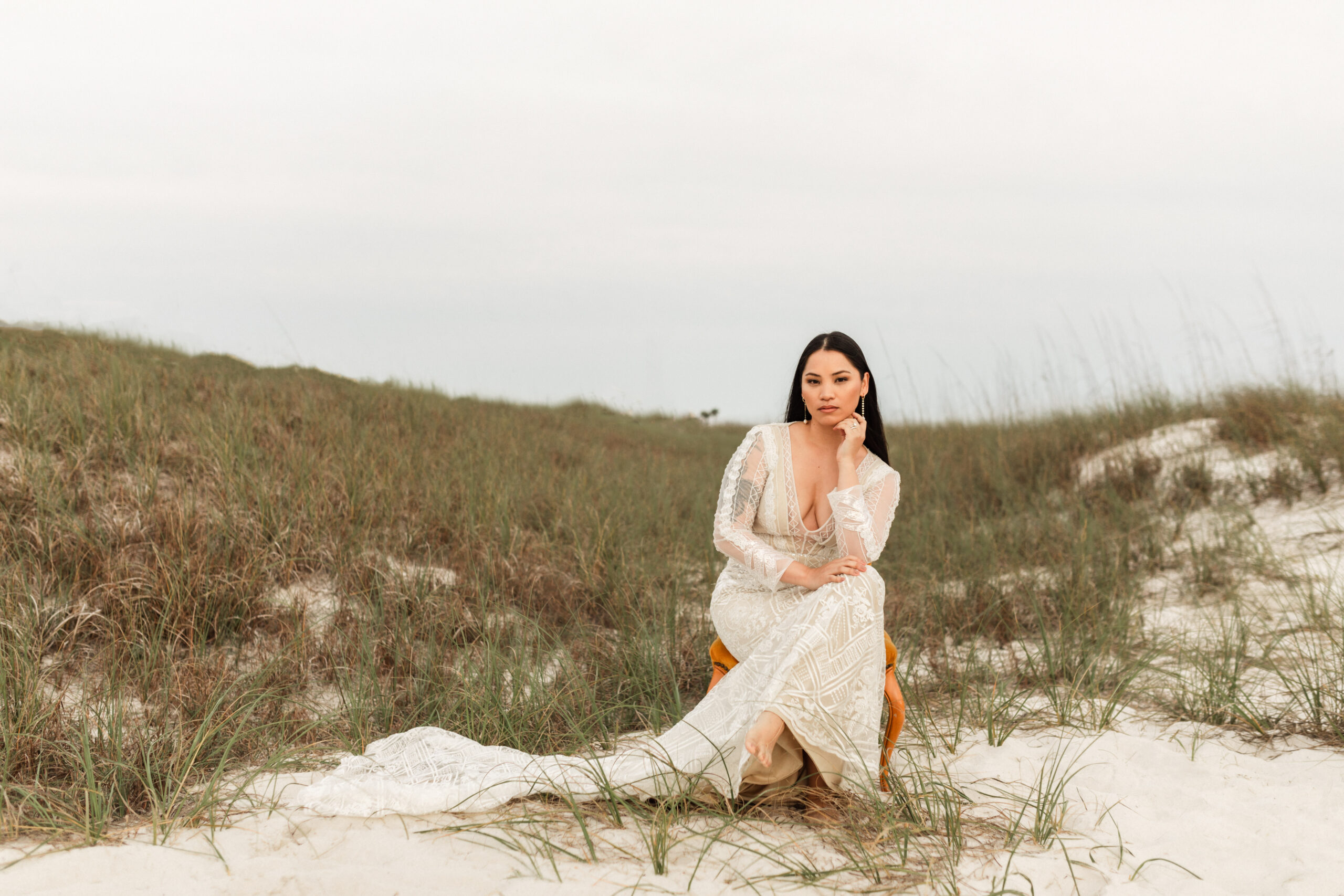 Bride posing regally on sand path in West PCB, Florida - wearing gown & holding flowers