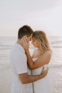 Newly engaged young couple embrace forehead to forehead at sunset on beach in PCB Florida 