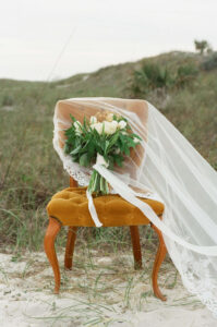 Film shot of veil, & bridal bouquet on vintage chair- from artist Brittney Stanley, who specializes in panama city wedding photography. 