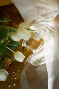 Film shot of veil, perfume, earrings & bridal bouquet on vintage chair in panama city beach florida- taken by wedding & portrait photographer Brittney Stanley of Be Seen Photos