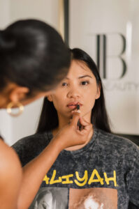 Makeup artist Tye Hinson of Hello Tye Beauty applies makeup prior to photo session
