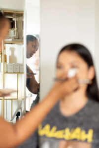 Makeup artist Tye Hinson of Hello Tye Beauty applies makeup prior to photo session