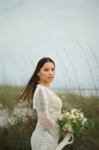 Film portrait of bride holding bouquet standing in middle of dunes on sand path in pcb florida.  Image taken by Panama City Wedding Photographer Brittney Stanley
